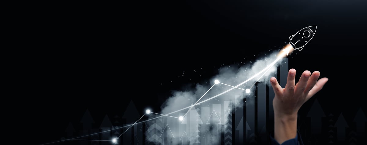 A hand supporting a launching rocket with rising growth chart — symbolizing startup growth and financial success